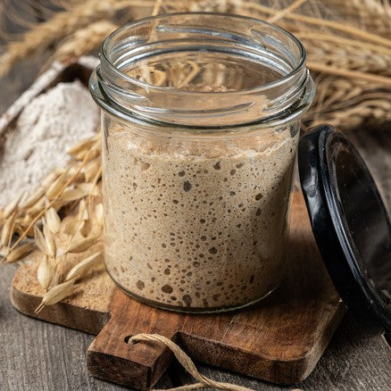 Active rye sourdough starter in a jar, perfect for baking tangy, probiotic-rich bread.