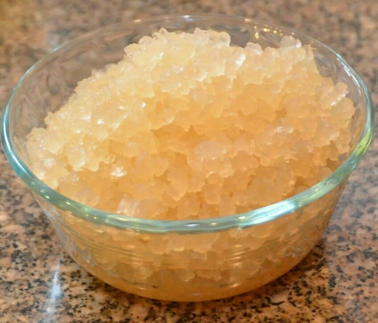 Close-up of a glass bowl filled with fresh, translucent live water kefir grains on a speckled countertop, ready for fermentation.