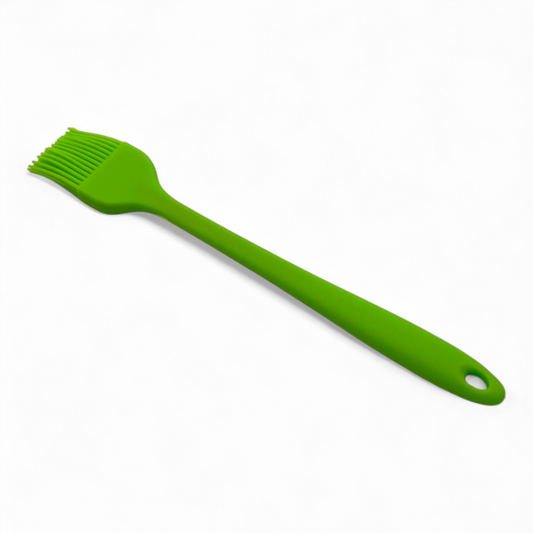 Green silicone pasty brush with a handle on a white background