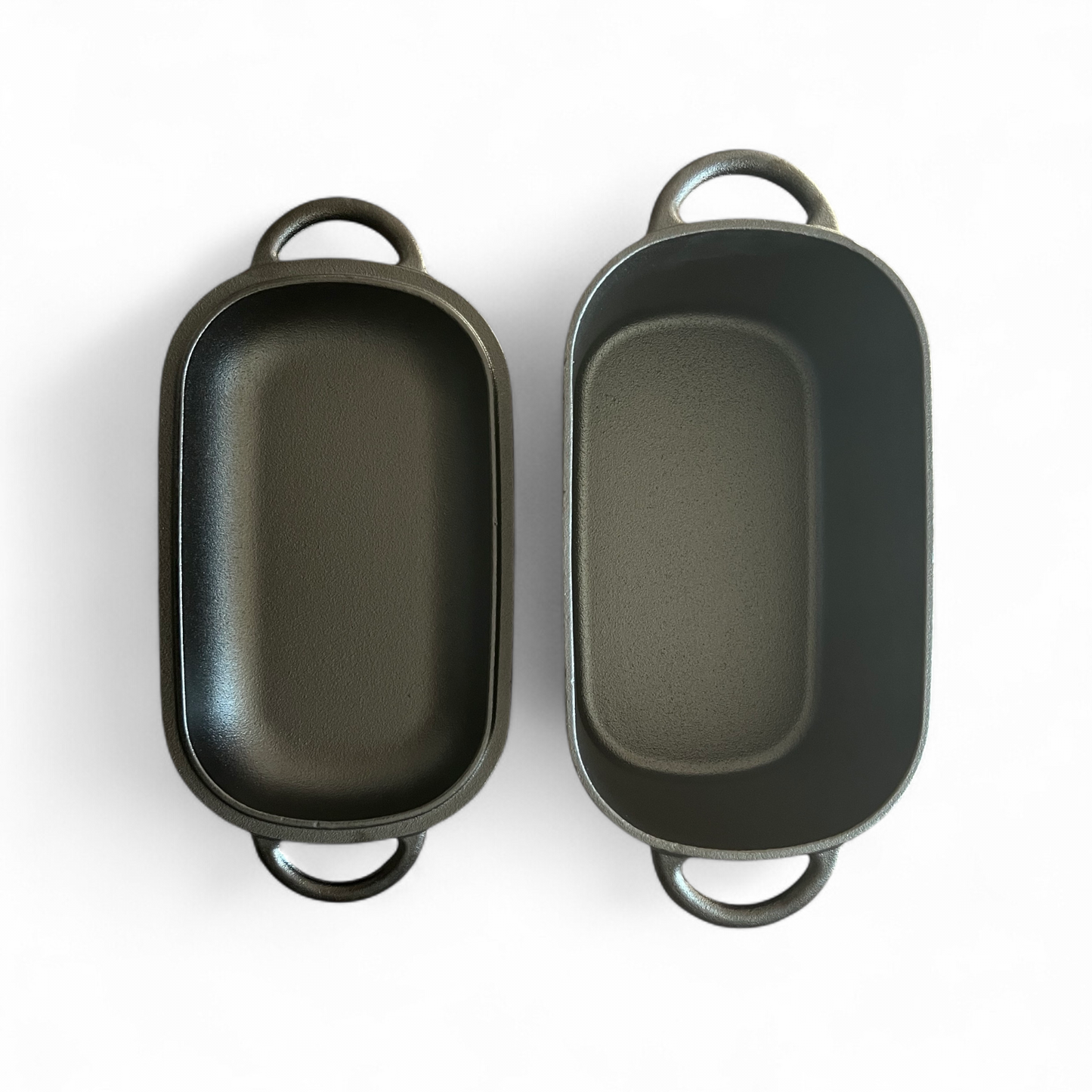 Lid and body of black dutch oven lying on white background next to each other. 