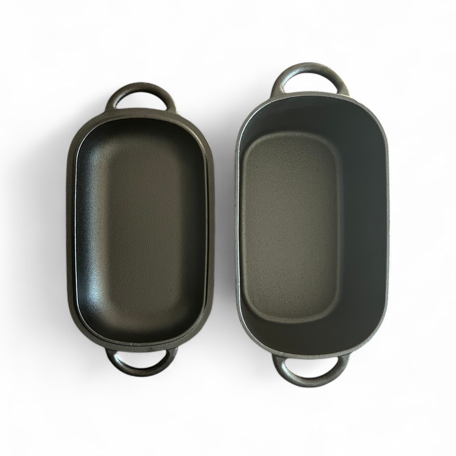Lid and body of black dutch oven lying on white background next to each other. 