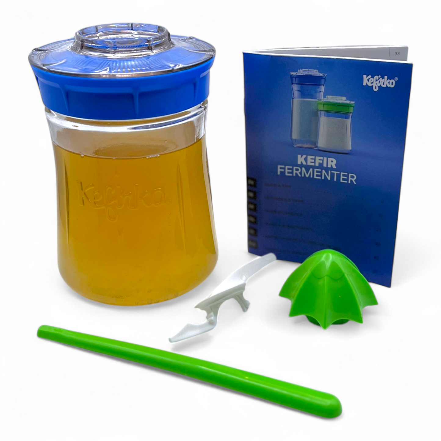 Small blue Kefirko fermenter with water kefir, accessories, and a Kefir guide on a white background