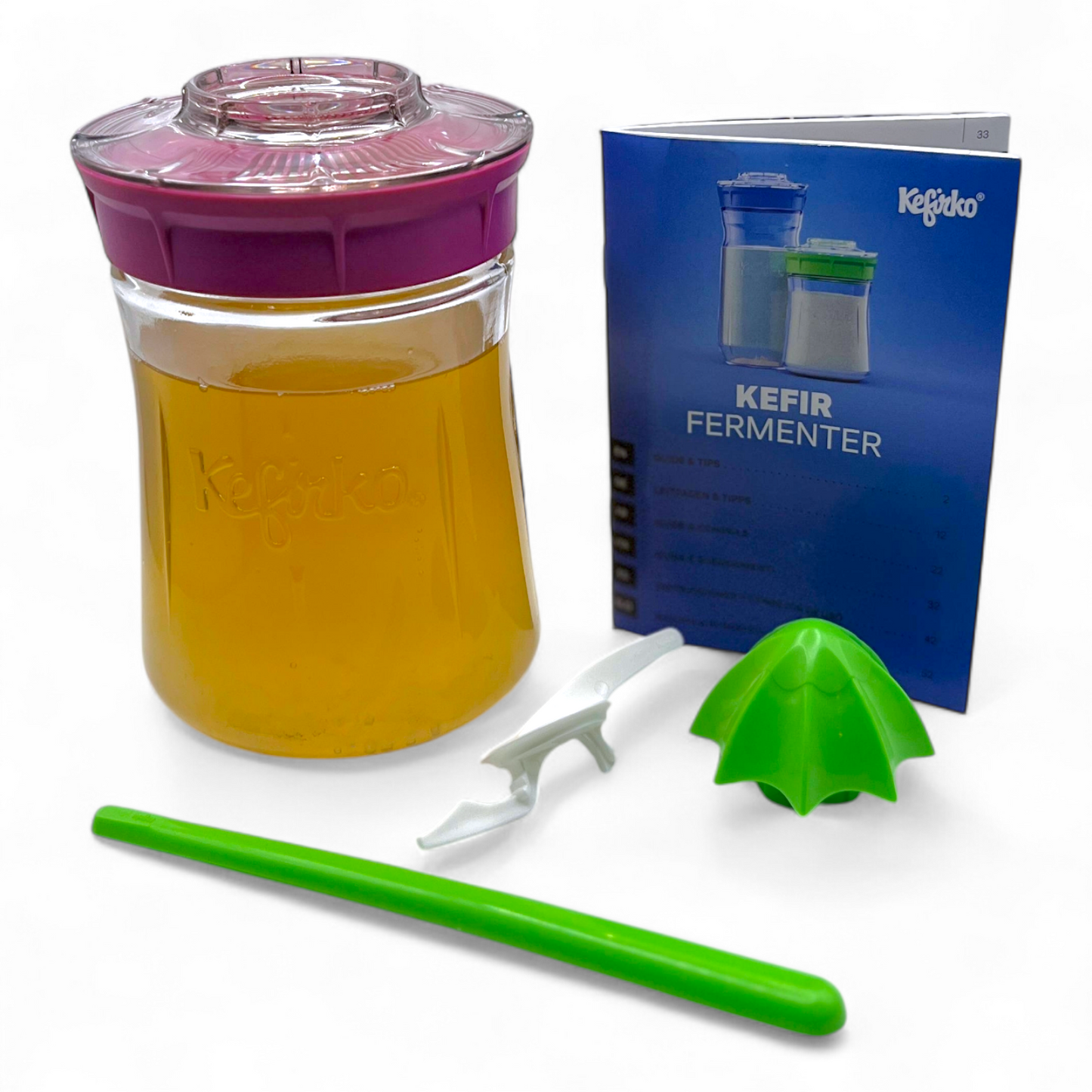 Small pink Kefirko starter kit with jar, water kefir grains, tool, and manual on a white background